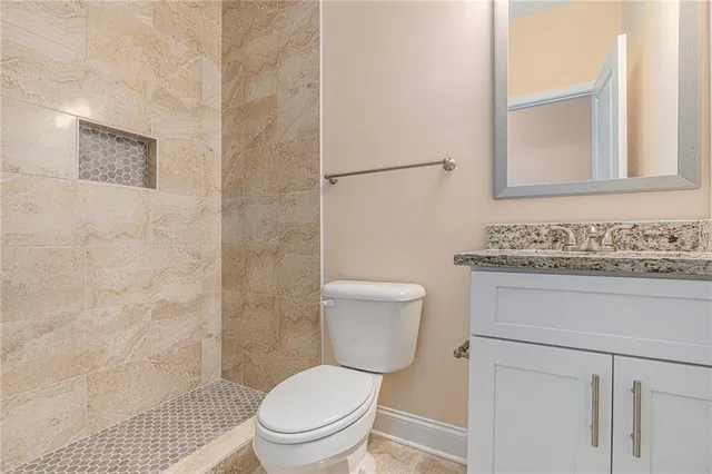 a bathroom with a granite countertop toilet sink and a mirror