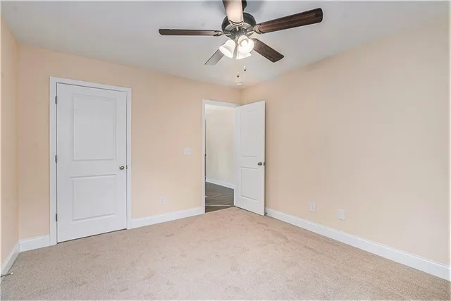 an empty room with a ceiling fan and a window
