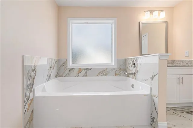 a bathroom with a bathtub and a window