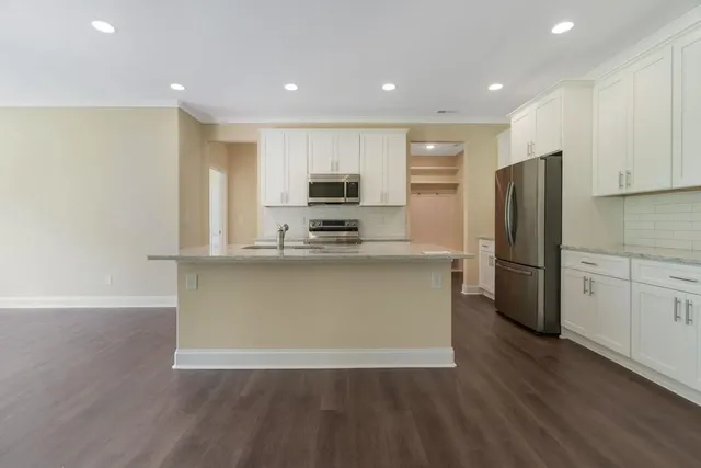 a kitchen with stainless steel appliances granite countertop a refrigerator a stove a sink and a microwave