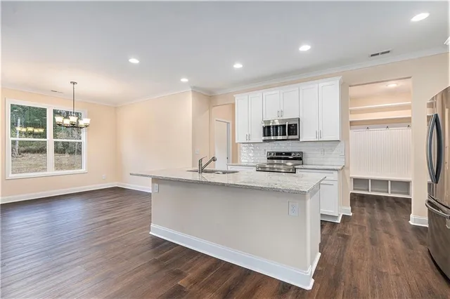 a kitchen with stainless steel appliances granite countertop a stove a sink and a refrigerator