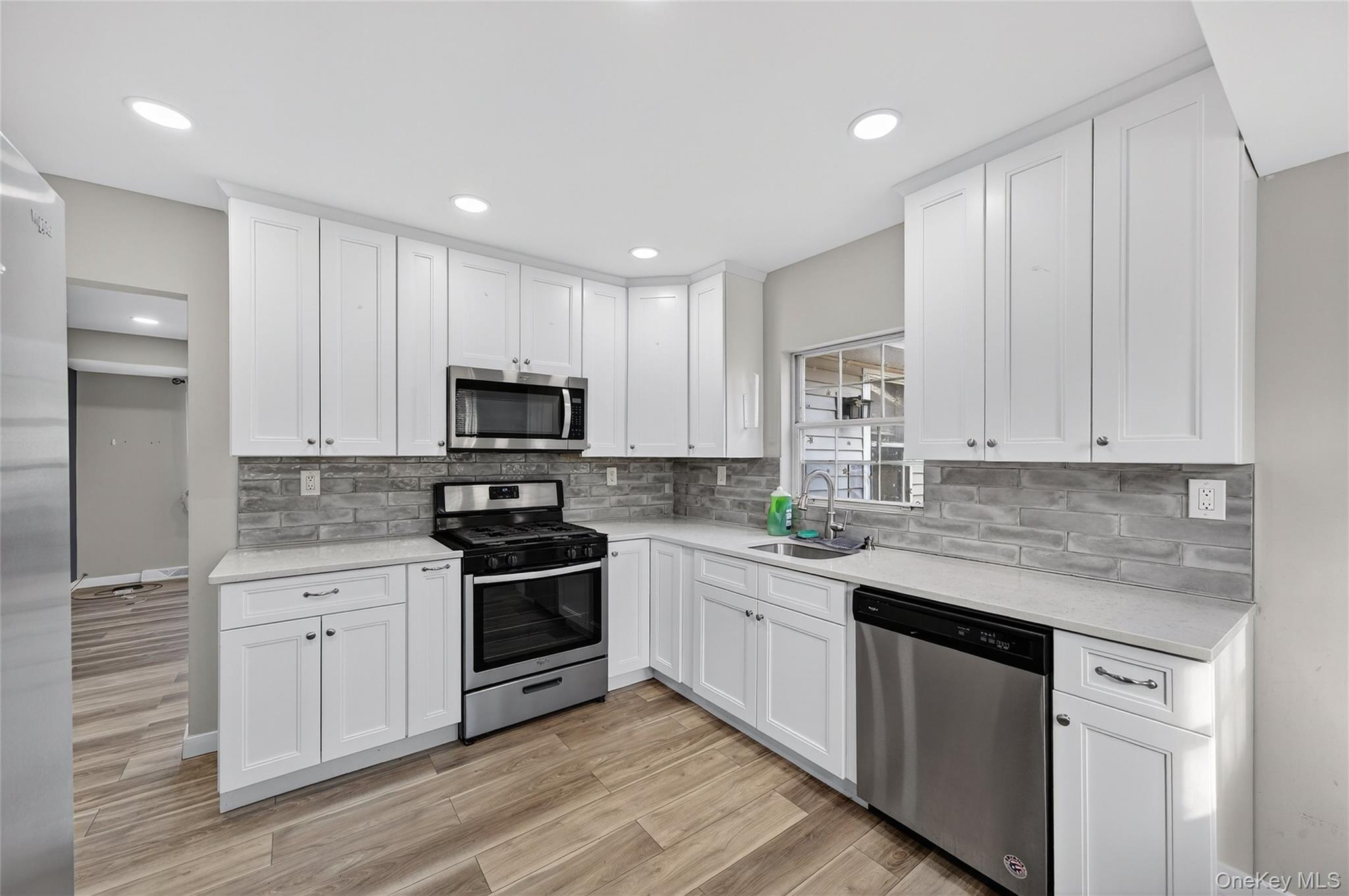 12 Revere Road Monroe, NY 10950 - Photo 11 of 30 Kitchen with stainless steel appliances, white cabinets, light stone counters, light wood finished floors, and recessed lighting