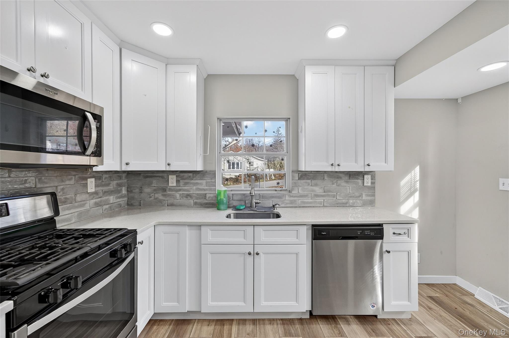 12 Revere Road Monroe, NY 10950 - Photo 12 of 30 Kitchen featuring stainless steel appliances, white cabinets, tasteful backsplash, light wood-type flooring, and recessed lighting