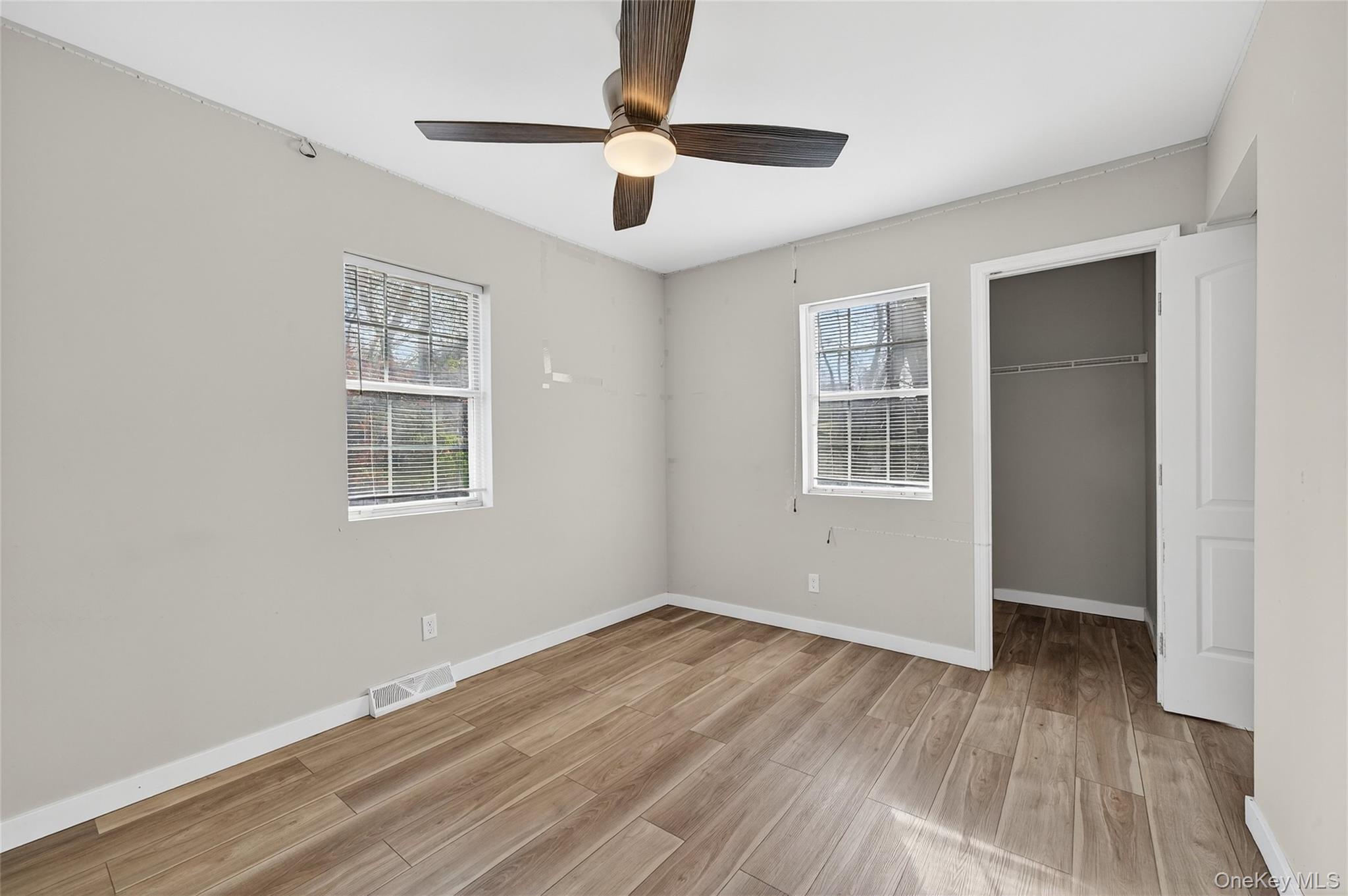 12 Revere Road Monroe, NY 10950 - Photo 24 of 30 Unfurnished bedroom with light wood-type flooring, a spacious closet, multiple windows, and ceiling fan