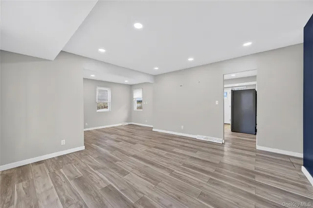a view of an empty room with wooden floor and closet