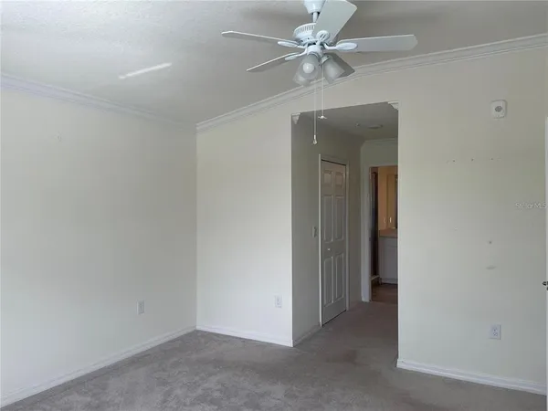 an empty room with a ceiling fan and a fan