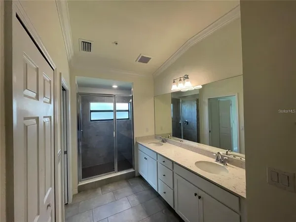 a bathroom with double vanity and a mirror