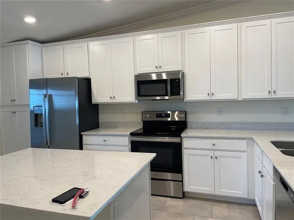 a kitchen with white cabinets and stainless steel appliances