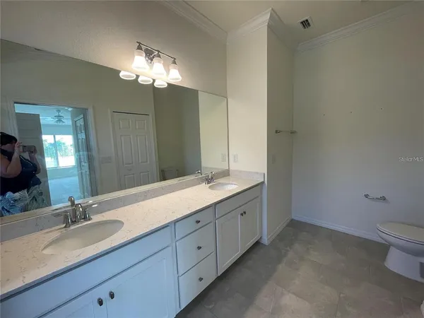 a bathroom with a double vanity sink and a toilet