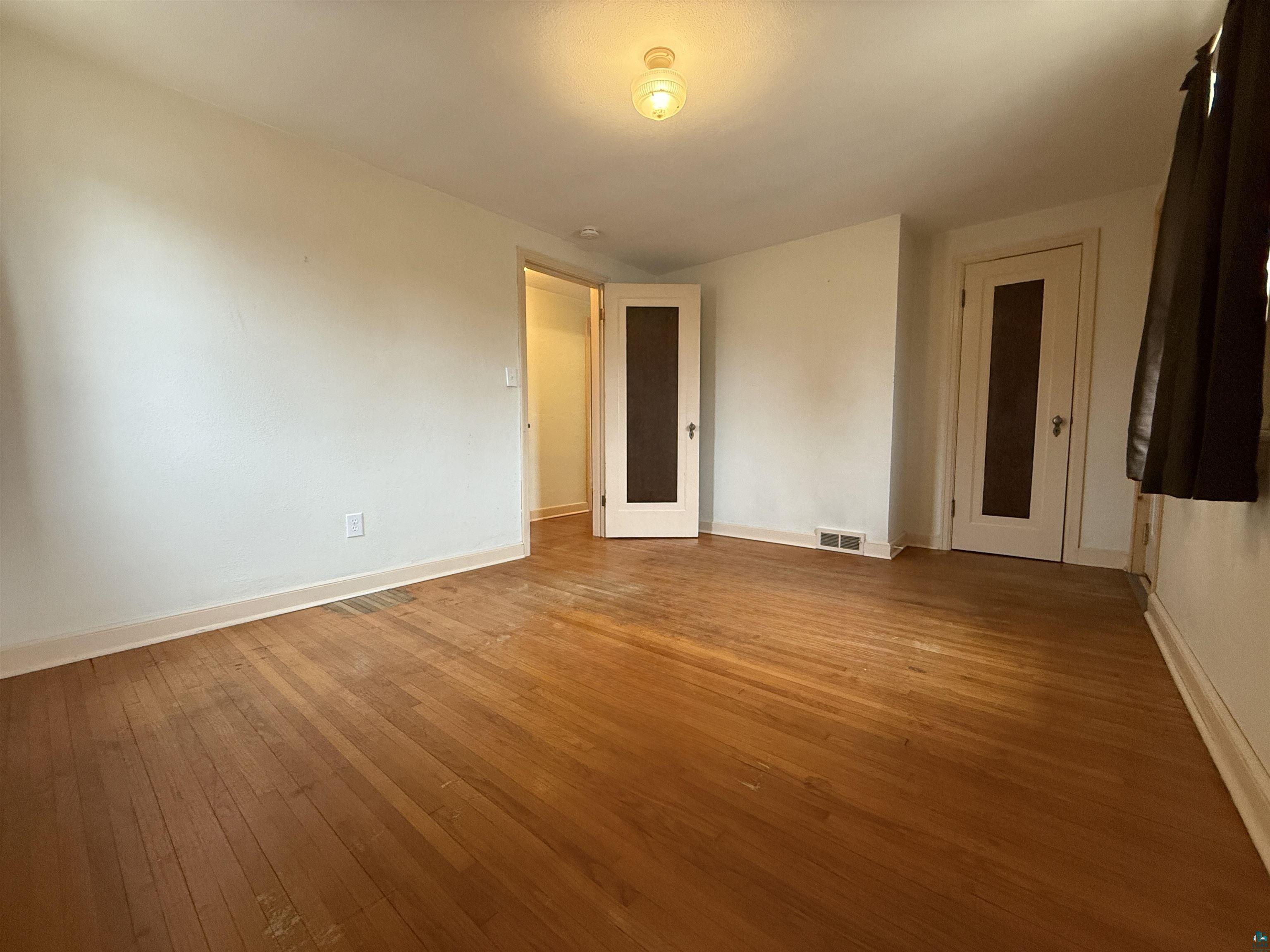 3001 3rd Avenue West Hibbing, MN 55746 - Photo 29 of 38 Unfurnished bedroom featuring light wood-style floors and baseboards