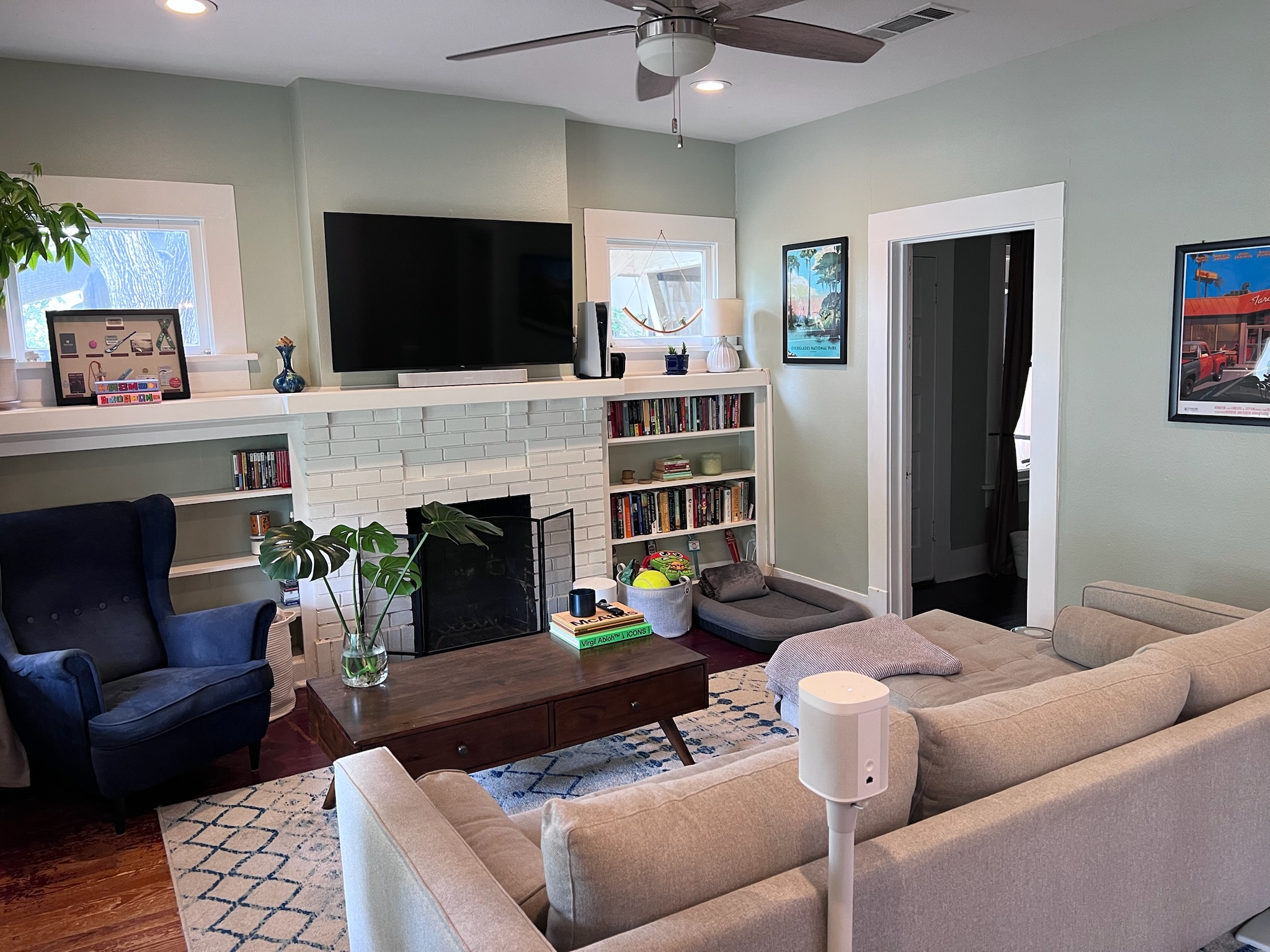 307 East 35th Street, Unit A Austin, TX 78705 - Photo 8 of 31 A welcoming living room features a classic brick fireplace, built-in shelving, and rich hardwood floors.
