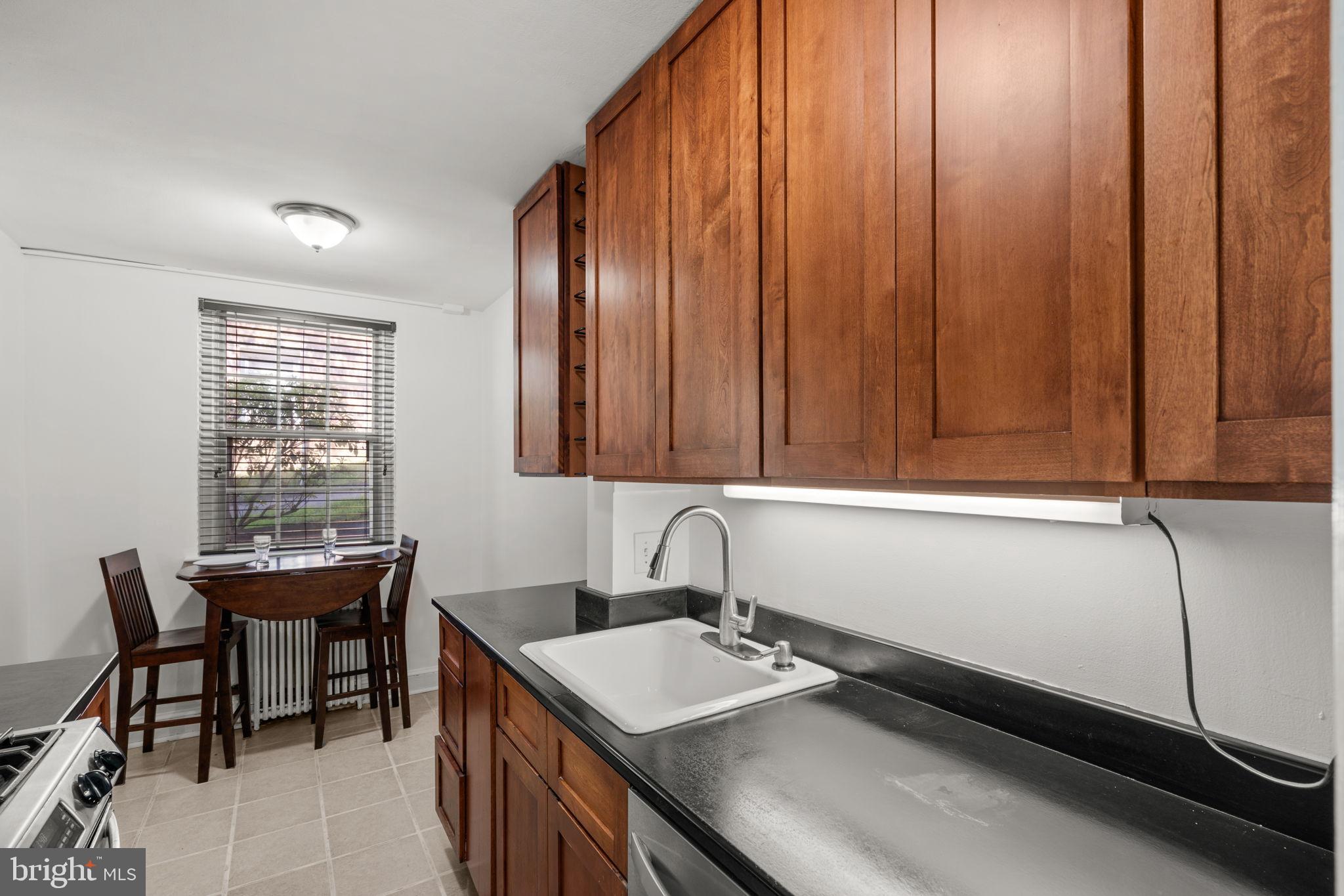 4581 MacArthur Boulevard Northwest, Unit 103 Washington, DC 20007 - Photo 12 of 28 a room with a sink cabinets and wooden floor