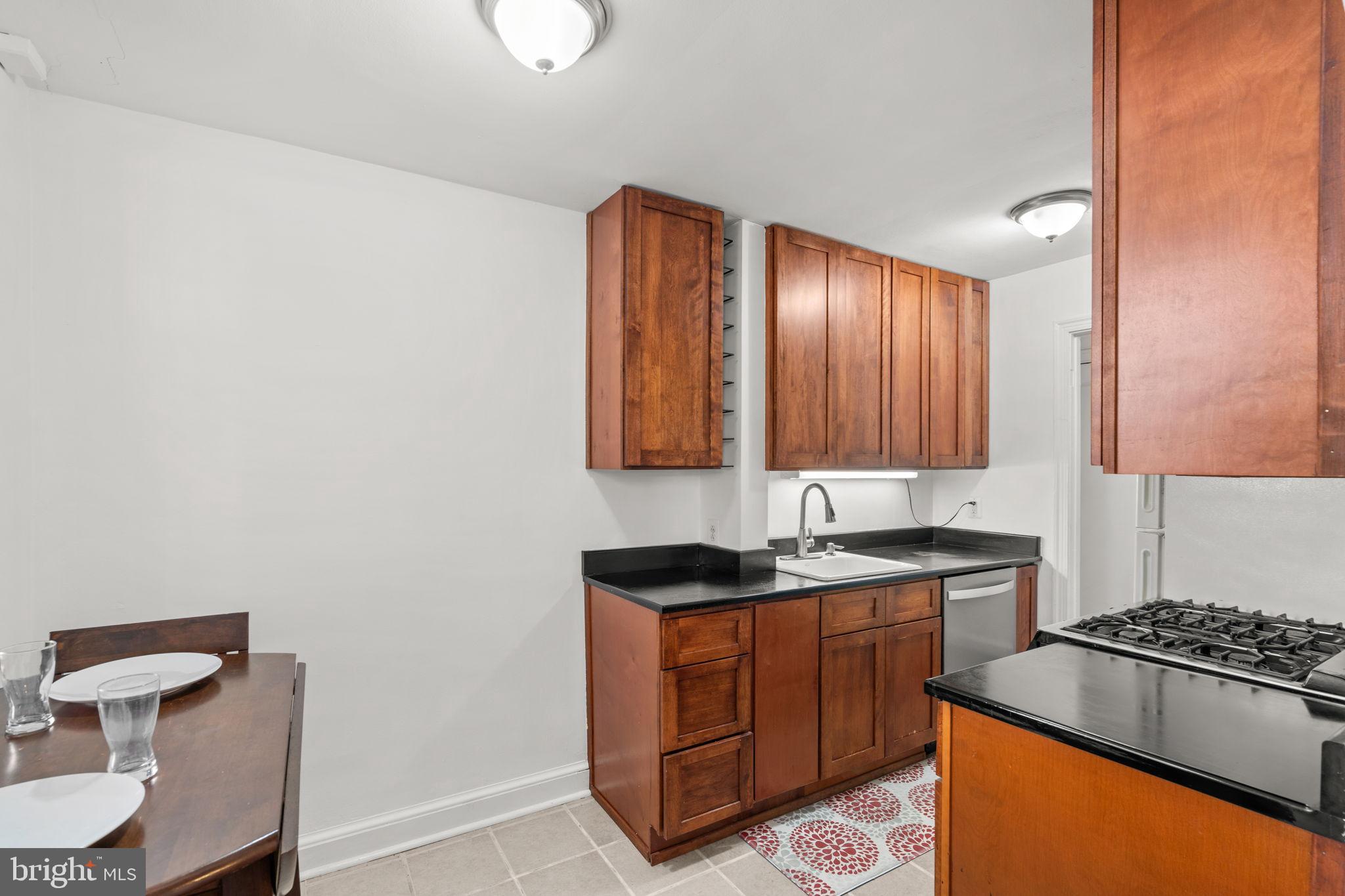 4581 MacArthur Boulevard Northwest, Unit 103 Washington, DC 20007 - Photo 13 of 28 a kitchen with granite countertop cabinets a sink and a stove