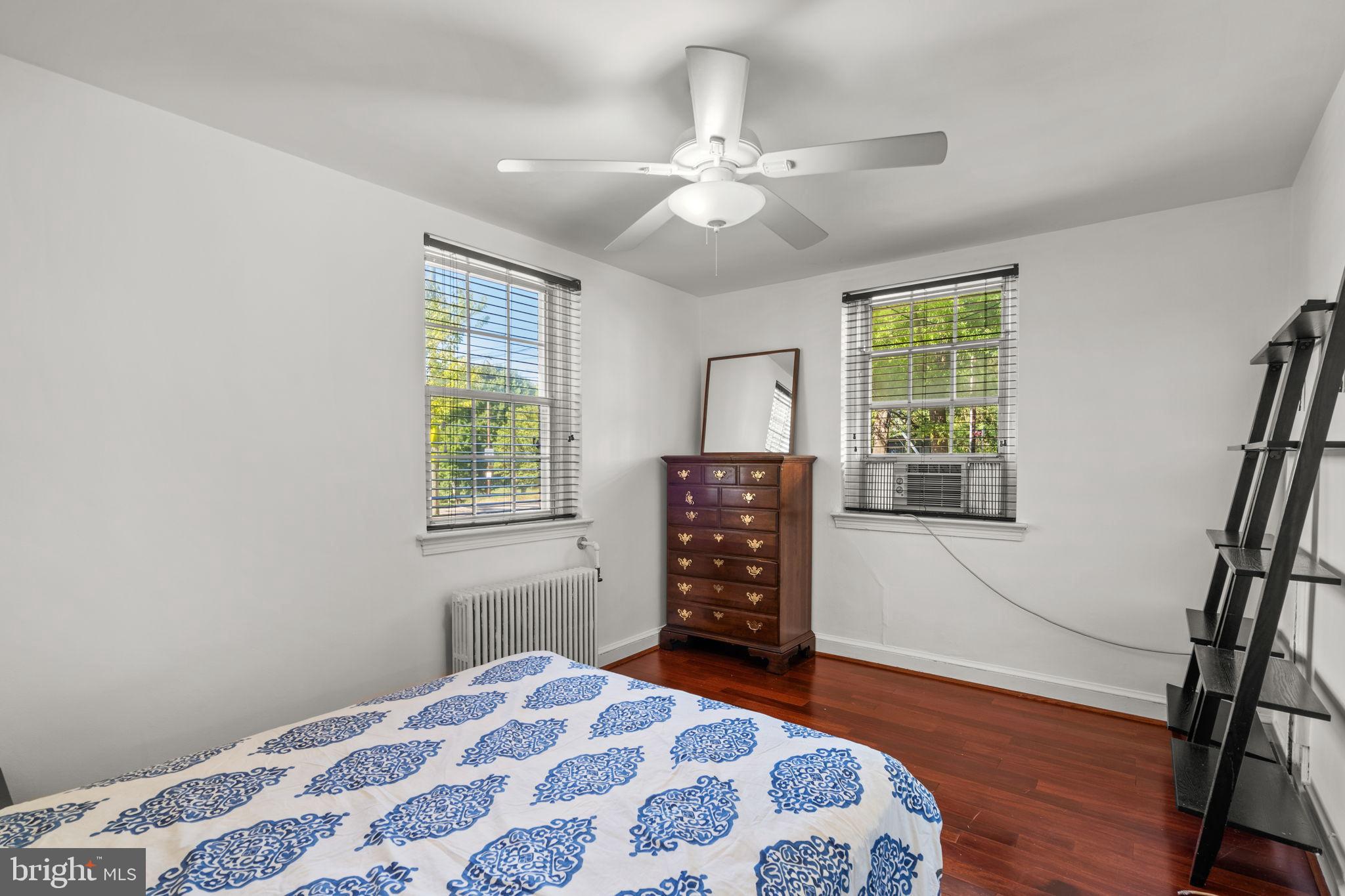 4581 MacArthur Boulevard Northwest, Unit 103 Washington, DC 20007 - Photo 18 of 28 a bedroom with a bed and wooden floor