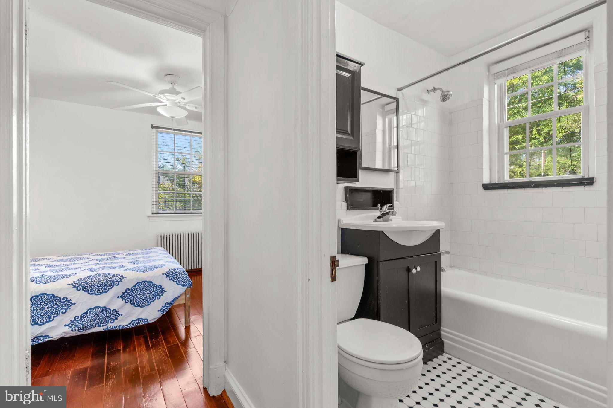 4581 MacArthur Boulevard Northwest, Unit 103 Washington, DC 20007 - Photo 22 of 28 a bathroom with a granite countertop sink toilet a mirror and bathtub