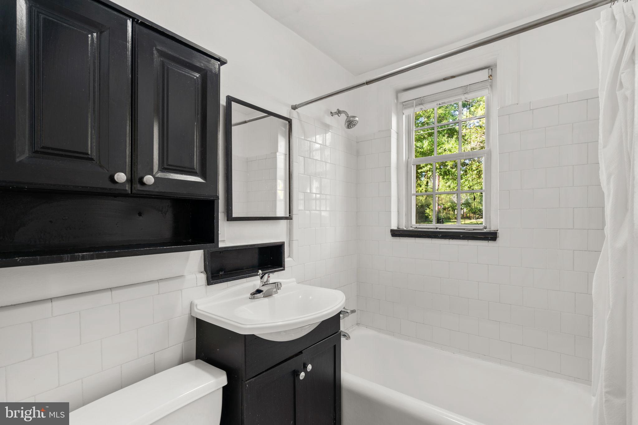 4581 MacArthur Boulevard Northwest, Unit 103 Washington, DC 20007 - Photo 23 of 28 a bathroom with a sink a toilet and tub
