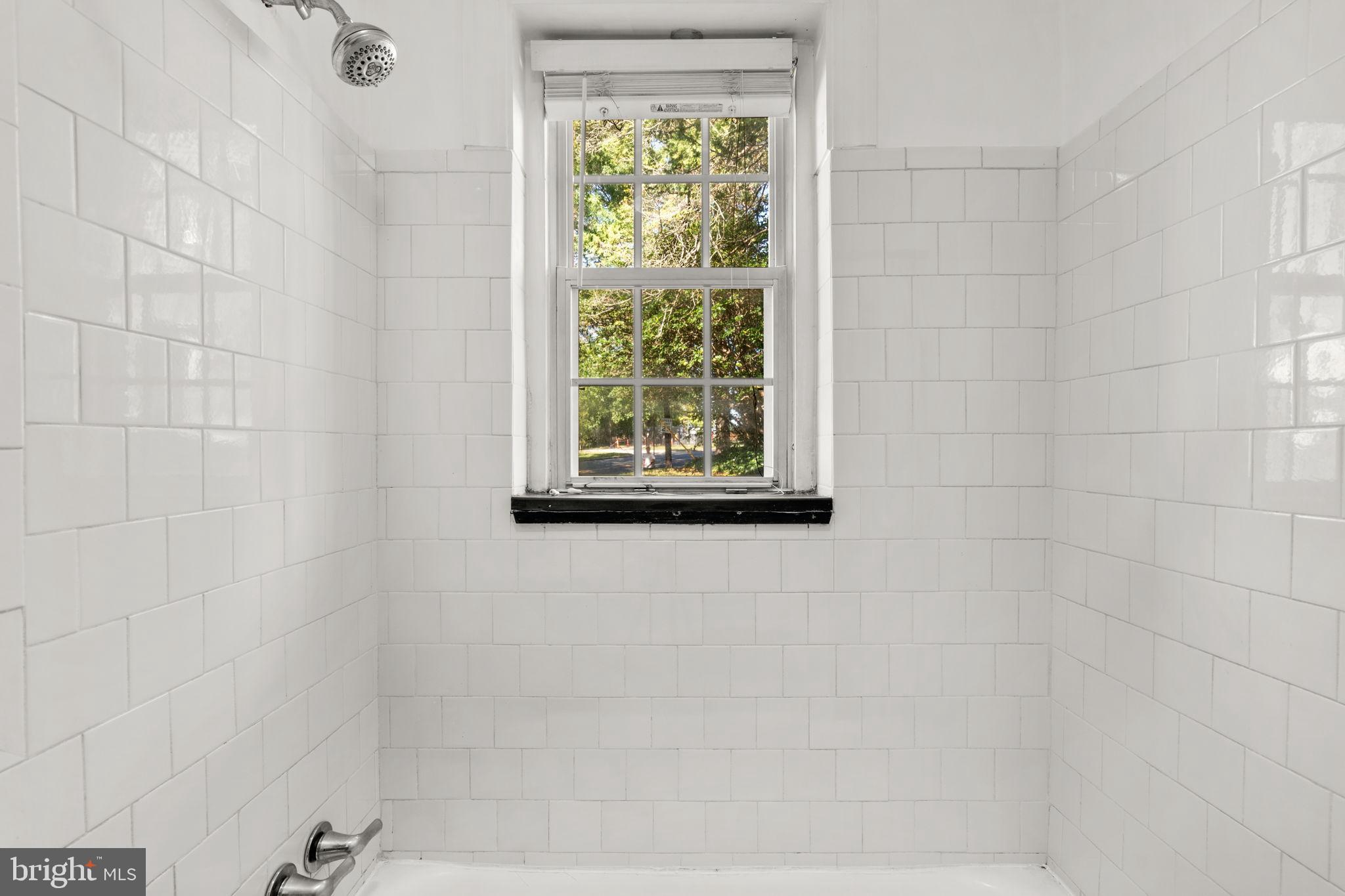 4581 MacArthur Boulevard Northwest, Unit 103 Washington, DC 20007 - Photo 24 of 28 a bathroom with a window and a shower