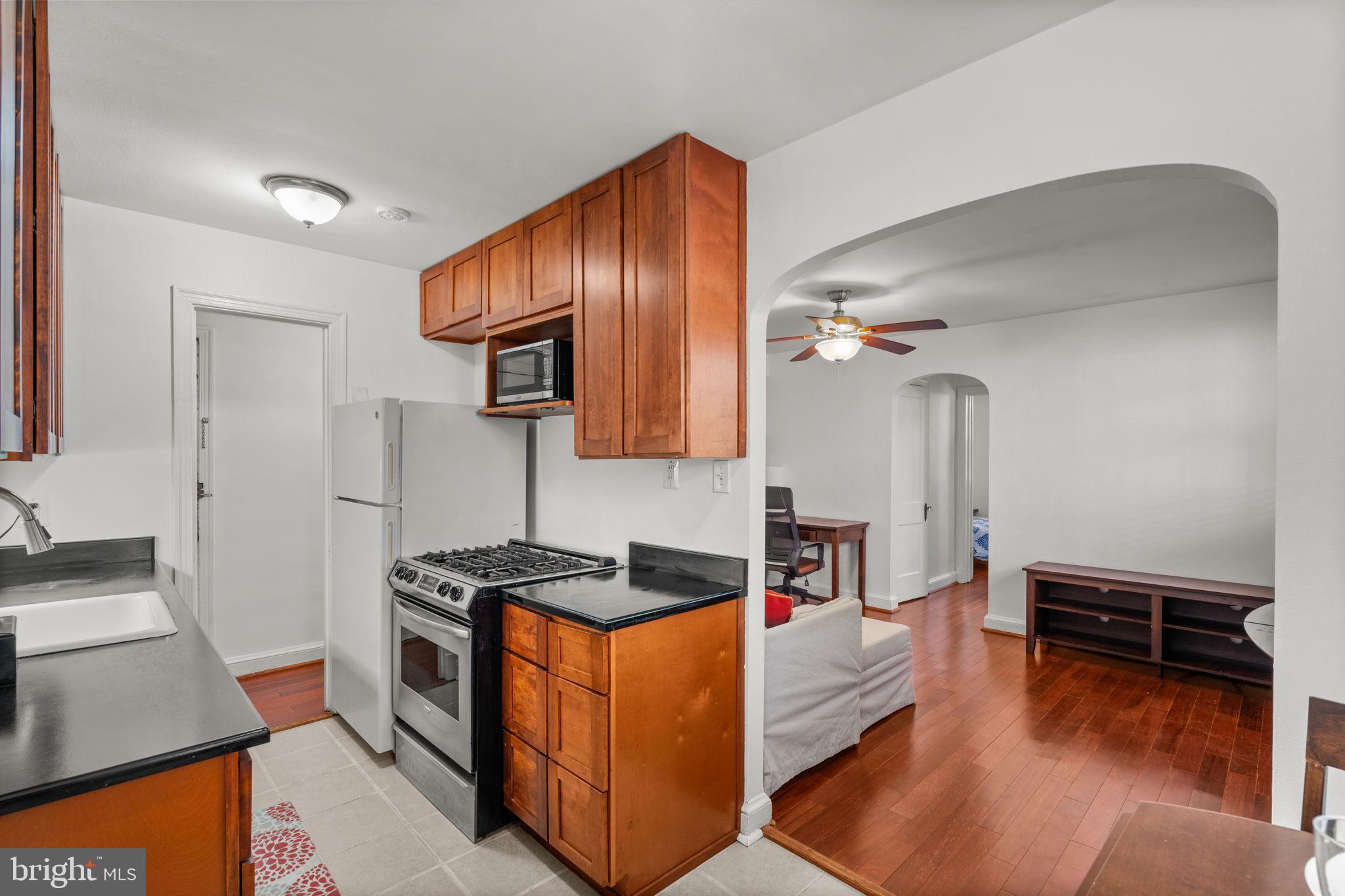 4581 MacArthur Boulevard Northwest, Unit 103 Washington, DC 20007 - Photo 8 of 28 a kitchen with stainless steel appliances granite countertop a stove a sink and a refrigerator