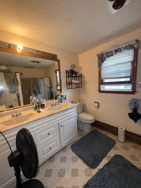 87 Exeter Street Lowell, MA 01850 - Photo 3 of 11 a spacious bathroom with a double vanity sink a mirror and a toilet