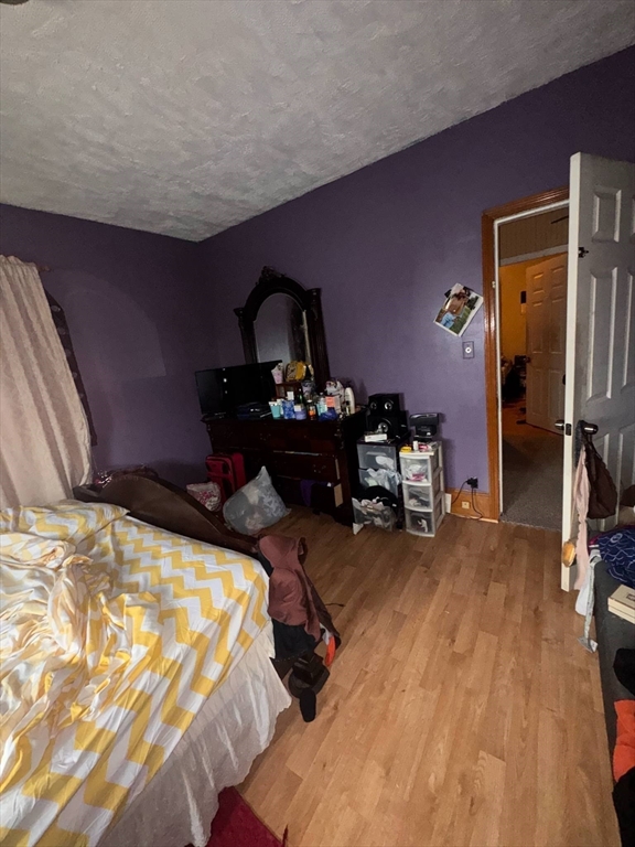 87 Exeter Street Lowell, MA 01850 - Photo 6 of 11 a bedroom with bed and a chandelier