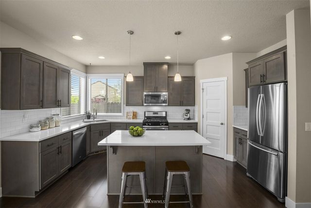 a kitchen with a sink stainless steel appliances and refrigerator