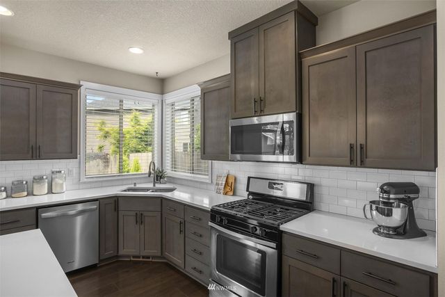 a kitchen with a sink stove and microwave