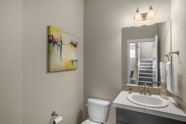 a bathroom with a sink vanity mirror and toilet