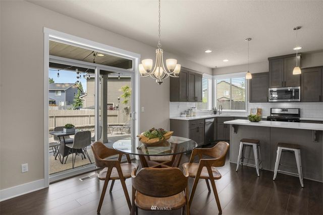 a dining room filled chandelier and wooden floor