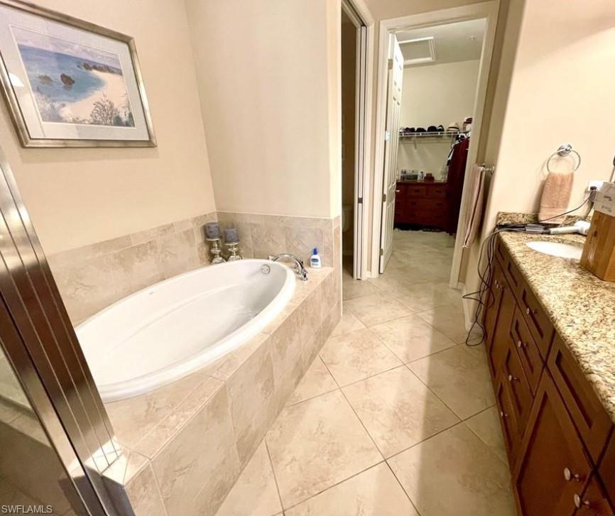 9050 Capistrano Street North, Unit 4102 Naples, FL 34113 - Photo 11 of 31 a spacious bathroom with a tub sink and mirror