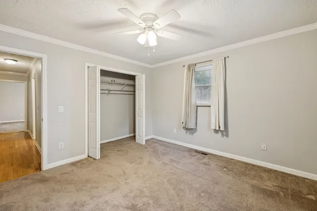 an empty room with windows and fan