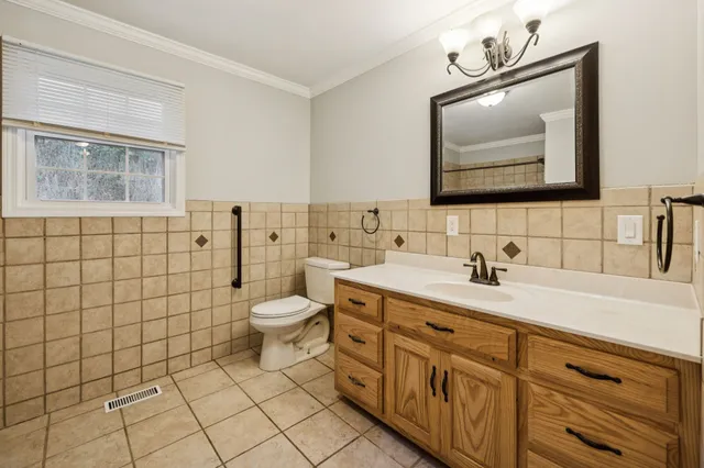 a bathroom with a toilet sink a mirror and shower