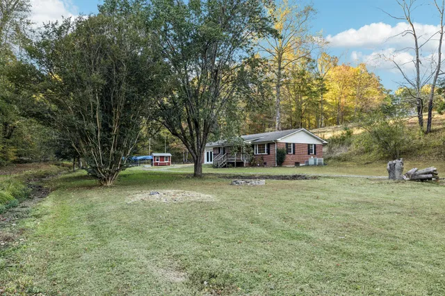 a view of a house with yard and sitting area