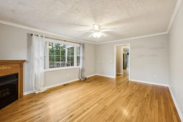 a view of an empty room with a fireplace and a window