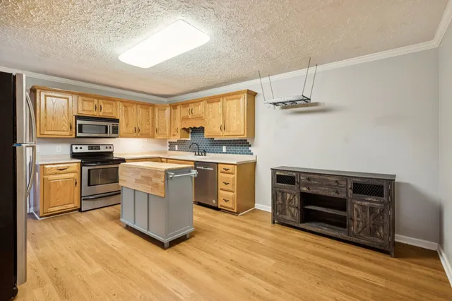 a kitchen with stainless steel appliances a stove a sink a microwave and cabinets