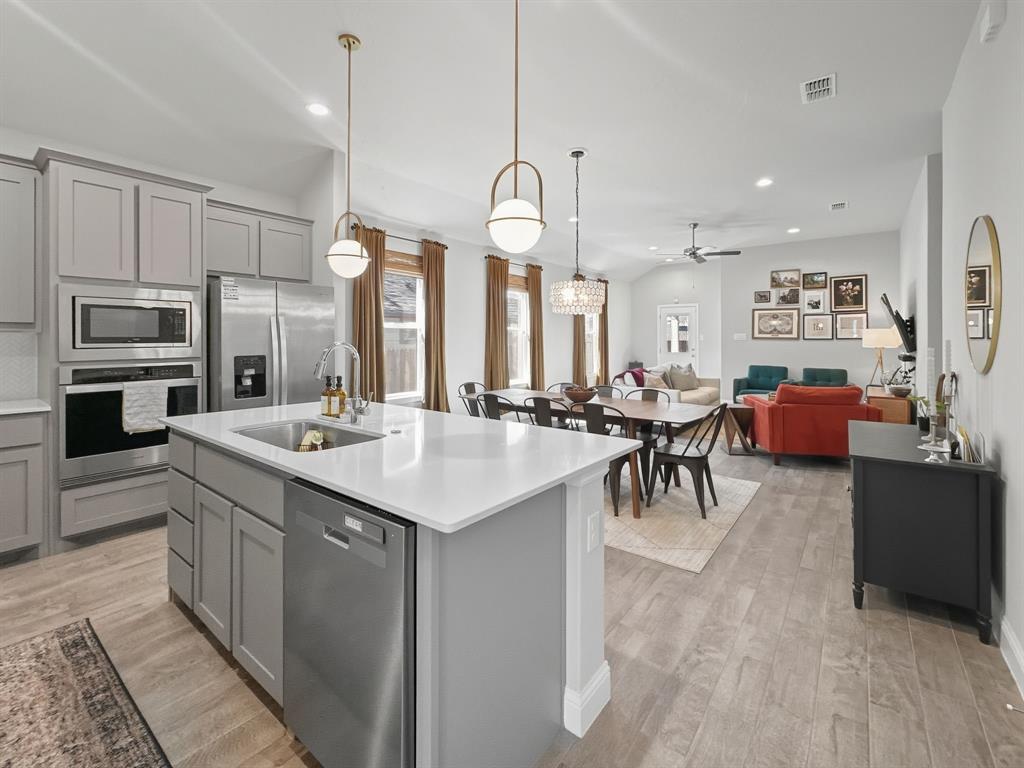 2216 Redwing Drive Denton, TX 76205 - Photo 7 of 38 a kitchen with sink a refrigerator and chairs