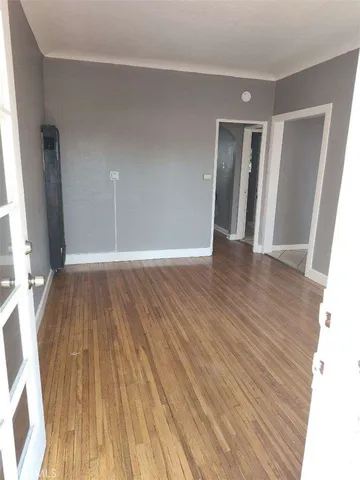 a view of a room with wooden floor and a window