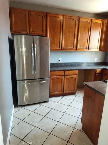 a kitchen with stainless steel appliances granite countertop a refrigerator a sink and cabinets