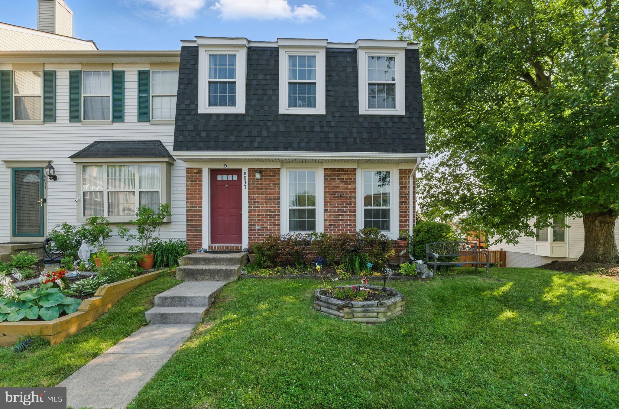 a front view of a house with yard and green space