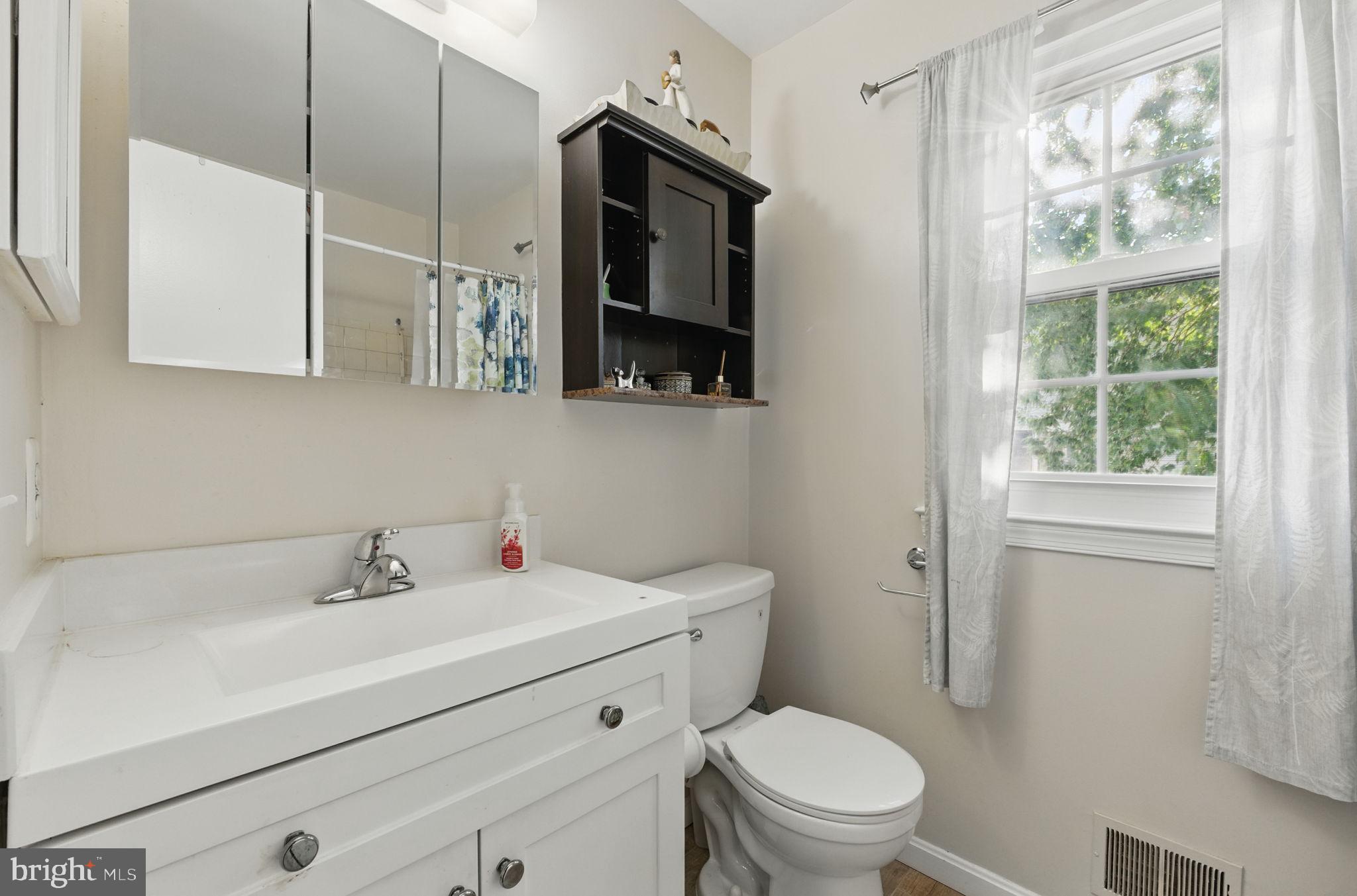 6837 Cottingham Lane Centreville, VA 20121 - Photo 16 of 25 a bathroom with a toilet sink a mirror and window
