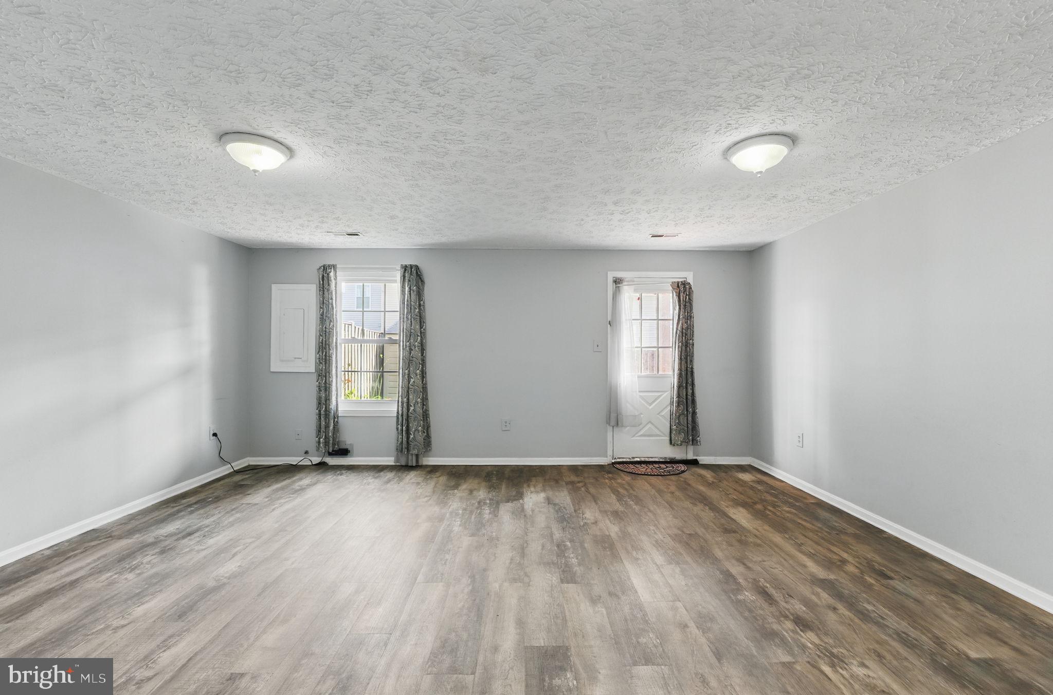 6837 Cottingham Lane Centreville, VA 20121 - Photo 18 of 25 an empty room with wooden floor and windows