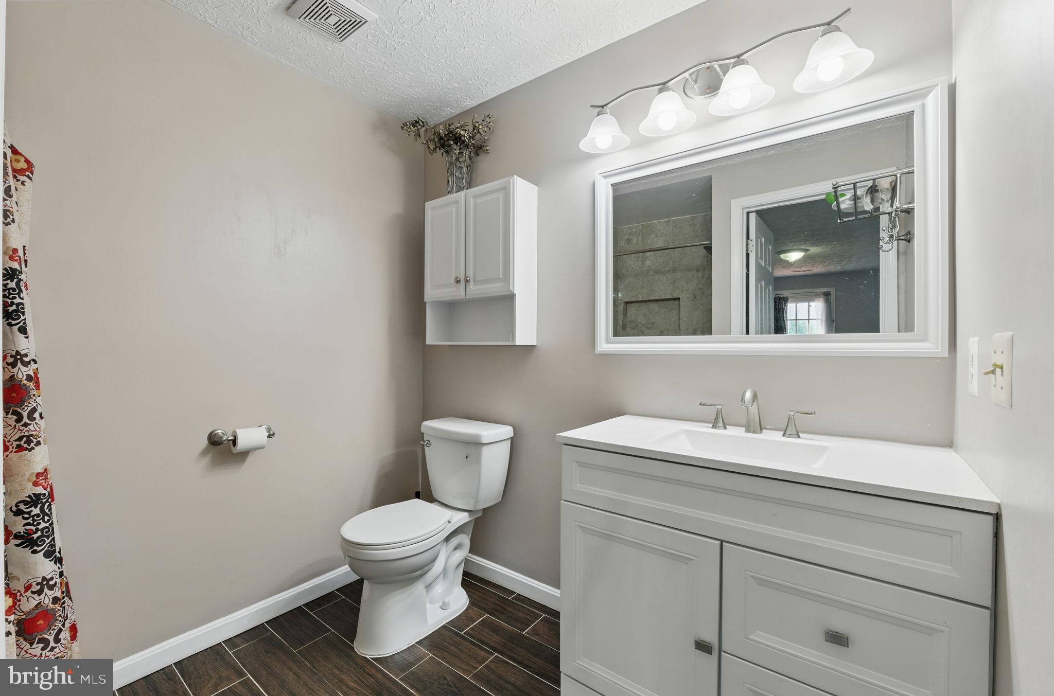6837 Cottingham Lane Centreville, VA 20121 - Photo 21 of 25 a bathroom with a toilet sink and mirror