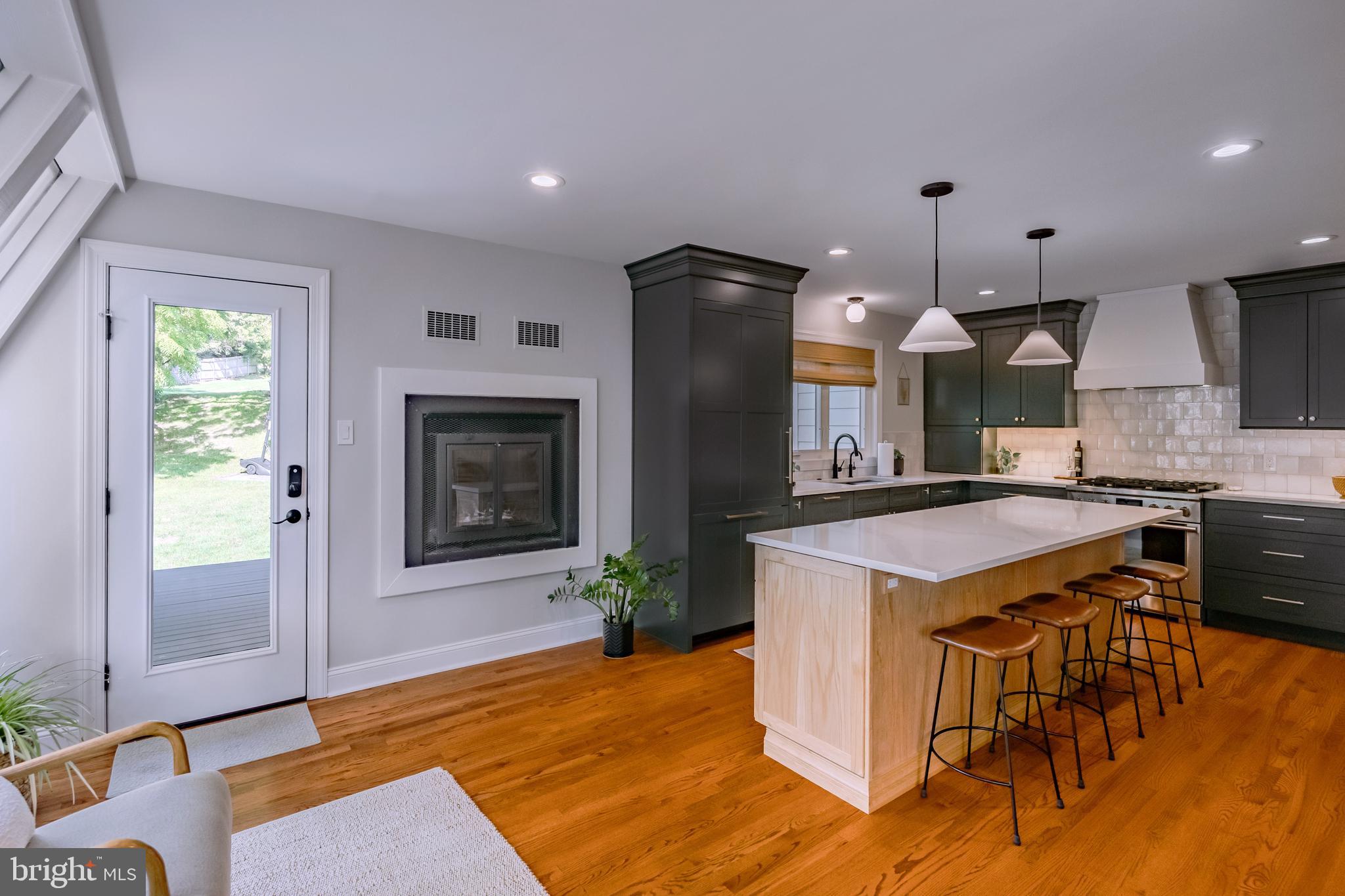 65 Roberts Road Newtown Square, PA 19073 - Photo 20 of 53 a kitchen with kitchen island a stove a refrigerator a oven a sink a dining table and chairs with wooden floor
