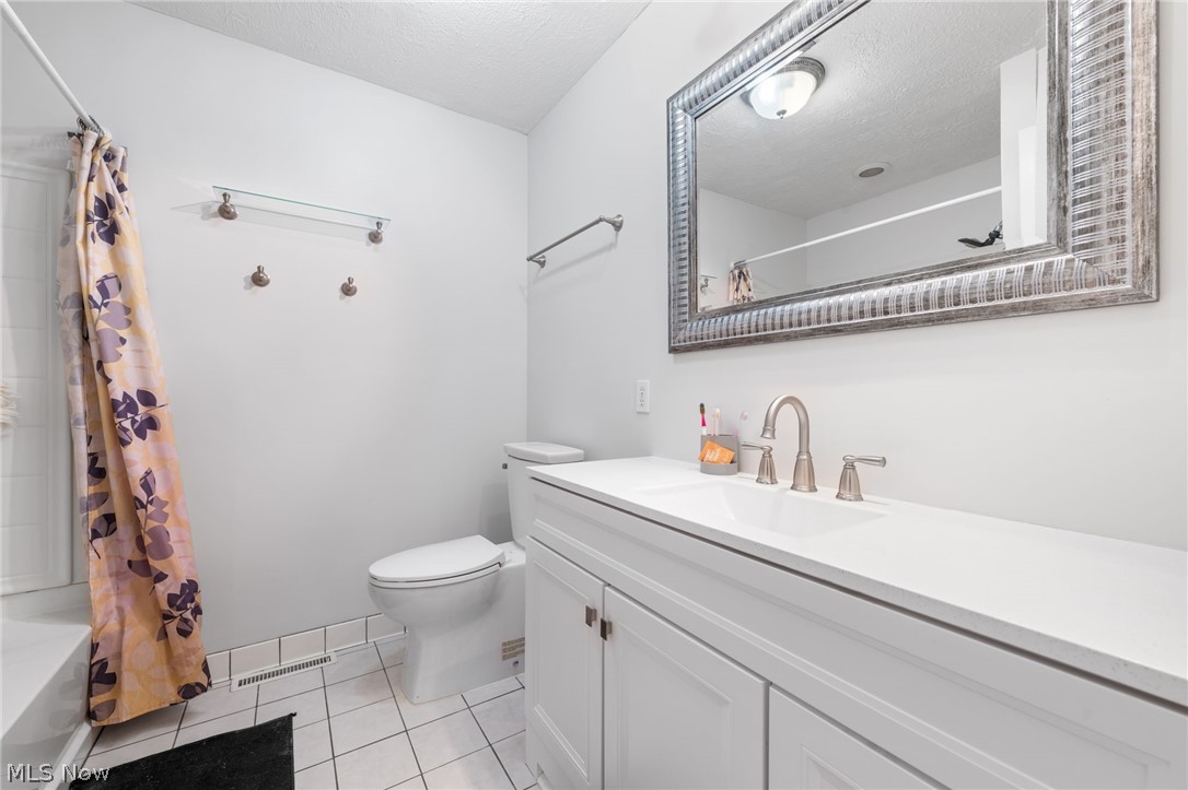 575 Walnut Ridge Trail Aurora, OH 44202 - Photo 14 of 20 Full bathroom featuring tile floors, toilet, large vanity, and a textured ceiling