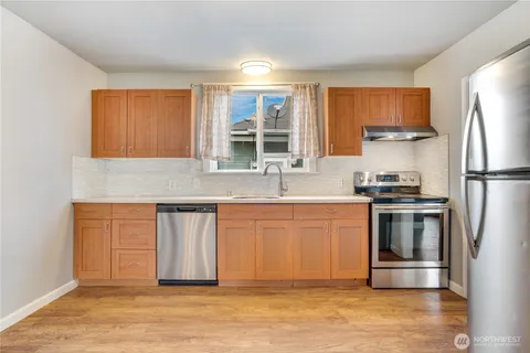 a kitchen with granite countertop a refrigerator stove and sink