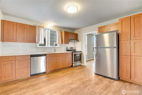 a kitchen with granite countertop a refrigerator and a sink