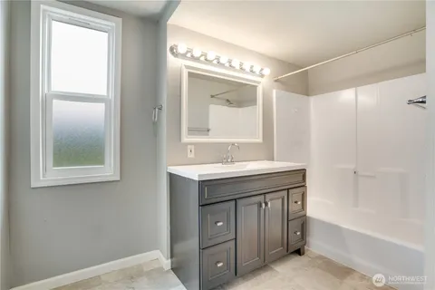 a bathroom with a double vanity sink a mirror and a bathtub