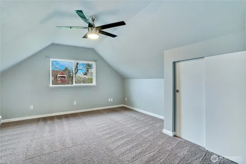 an empty room with a ceiling fan and window