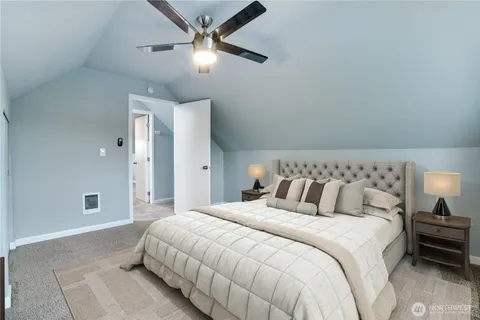 a bedroom with a large bed and a ceiling fan