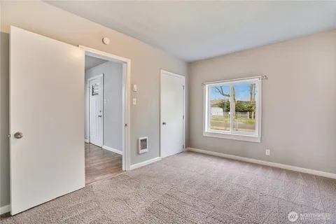 an empty room with windows and closet