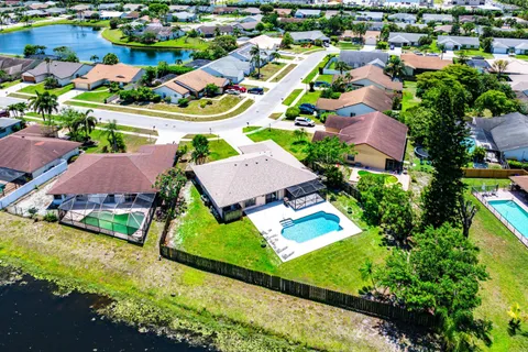an aerial view of residential houses with outdoor space and a lake view